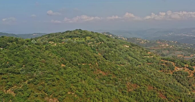 Tanneron France Aerial v17 establishing breathtaking shot, drone flyover a hill reveals foothill village, green valleys and rural plantations on a tranquil sunny day - July 2021