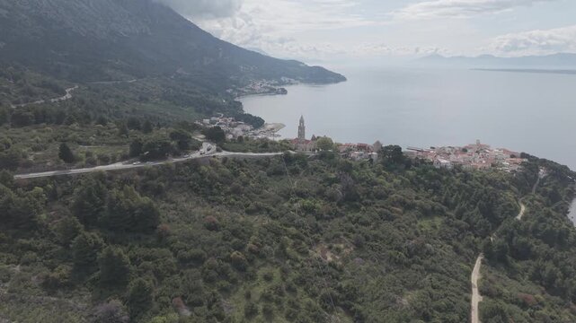 Aerial View of Coastal Village with Church Tower and Mountain Bay