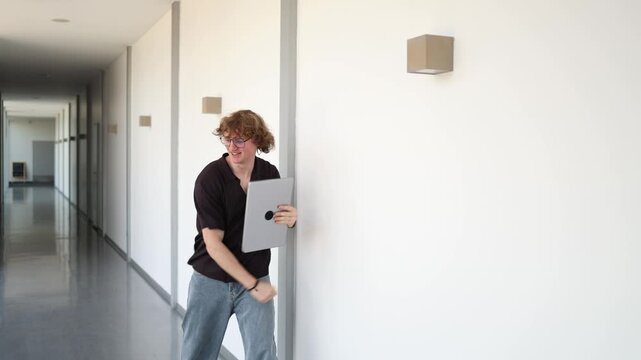 Successful IT specialist celebrates completed project raising laptop and backpack with joy after productive work expressing achievement victory motivation and relief