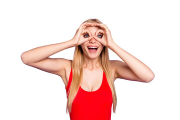 Attractive blonde student foolish girl wearing red swim suit showing imitation glasses gesture. Isolated over violet pastel background © deagreez
