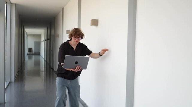 Student barely stays on feet after exhausting study session leaning on wall while holding laptop showing burnout fatigue academic overload and mental exhaustion