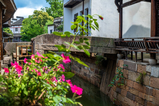 Jishan Bridge Digang Ancient Village Huzhou, Zhejiang, China, carved ancient stone bridge flowers foreground Jiangnan canal scenery