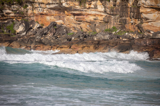 Ocean Waves Crashing Against Rocky Cliff Face
