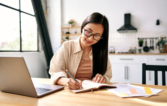 Young woman studying at home with laptop.