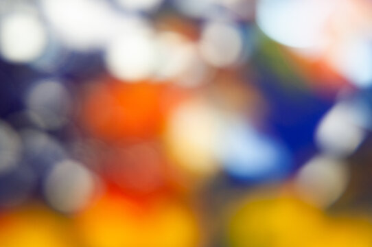 Colorful shapes blend in a blurred background during a lively event in the city