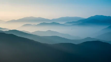 Fotobehang Rustgevend Misty Blue Mountain Layers at Sunrise with Soft Atmospheric Landscape  © Michael Karter