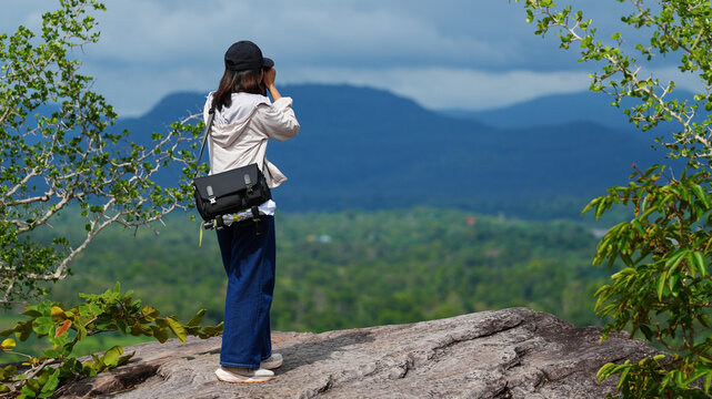 Female photographer capturing scenic mountain landscape from a viewpoint