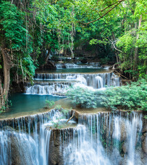 Multi-tiered tropical waterfall cascade flowing into turquoise pool surrounded by dense green forest with waterfall ©  SobuzForge