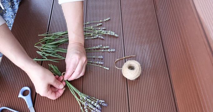 Hands tying bow on lavender bouquet video clip. Social media content creator blogging backdrop for creative floristry layout. Elegant minimalist aesthetic decoration with copy space for design trend.