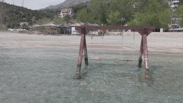 Wooden Swing Set Standing in Crystal Clear Turquoise Sea