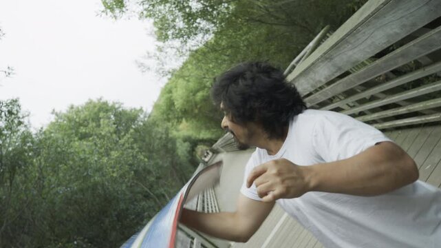 Man Tossing Painted Board into Air And Doing Cool Trick on Wooden Footbridge
