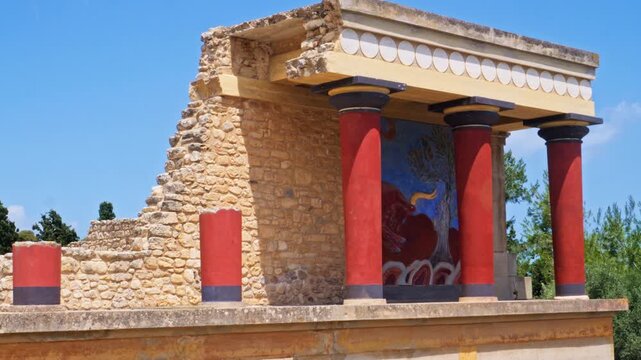 Minoan Palace of Knossos, a famous archaeological site located in Crete, Greece. Tourists visiting the ancient historical ruins on a sunny summer day. Historical landmark of Mediterranean civilization