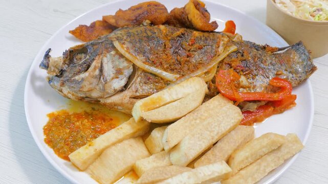 Fried whole tilapia fish meal with fried yam wedges and plantains