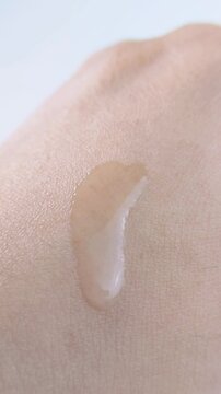 Top close up of pouring clear liquid onto hand skin. Beauty skincare concept, refreshing hydration for daily skin care routine.