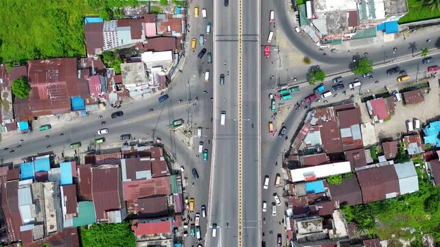 Busy urban flyover crossing a city intersection with traffic flow, top down aerial