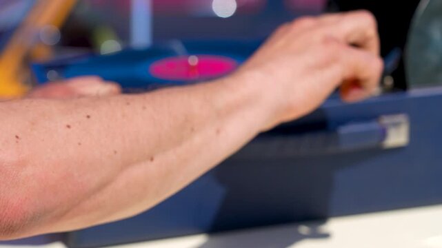 Hands playing a vinyl record on an old gramophone