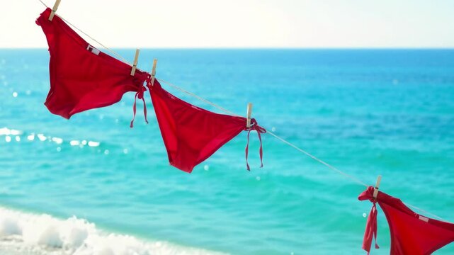 Red Flags Waving Against Bright Blue Ocean Water on a Sunny Day for Summer Vacation Concept