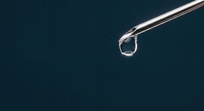 A single clear liquid drop precisely forming at the tip of a sterile hypodermic needle, emphasizing medical accuracy and scientific application in healthcare