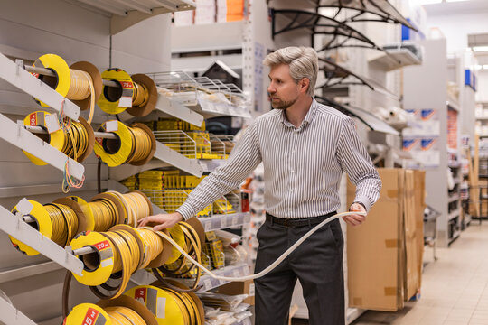 Young man shopping or working in a hardware warehouse standing