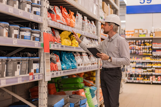 warehouse employee studies goods in a hardware store and checks the availability of goods