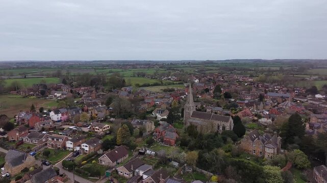 Aerial Side View of Walgrave Village Skyline With Church Tower in Northamptonshire England