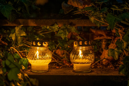 Votive Candle Lights On Tombstone At Night