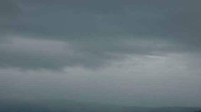 Silhouette of distant mountain ranges and gray clouds