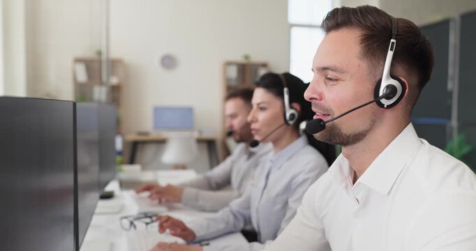 Agent operator with headset handles call support service. Focused in an office, helpdesk staff assist customer inquiries and manage hotline traffic efficiently. Clear concept of client care.