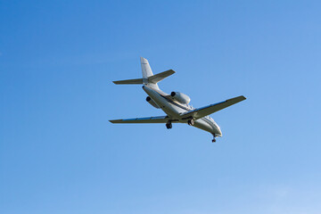 Private business jet approaching for landing against a clear blue sky   Prywatny odrzutowiec biznesowy zbliżający się do lądowania na tle czystego, błękitnego nieba © Adrian White