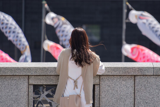 風にたなびく鯉のぼりと女性の髪
