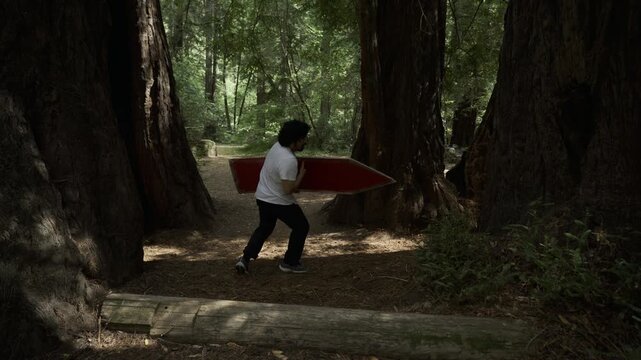 Man Spinning Painted Board And Doing a Backflip Among Giant Redwood Trees - Steady Cam Shot