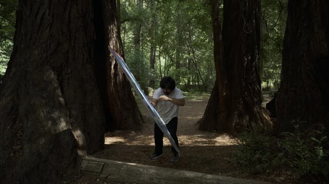 Man Doing Flip And One-Arm Handstand Next to Giant Redwood Tree In California Forest