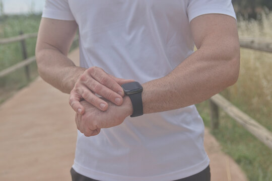 Joven deportista mirando su reloj inteligente deportivo