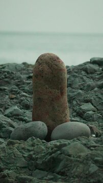 Stones beach arrangement on a rocky shore with smooth pebbles set against a blurred background of the sea