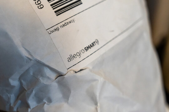 Warsaw, Poland - July 5, 2026: Close-up of crumpled delivery package featuring labeling elements such as barcodes and sender's instructions, representative of online shopping experience in the e-comm