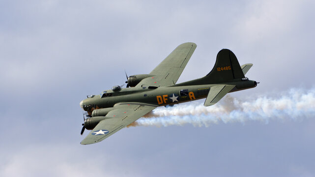 Vintage  B-17 Flying Fortress G-BEDF Sally B with smake and cloudy flight sky.