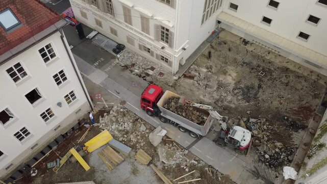 Aerial view of excavator loading rubble onto a truck at a construction site