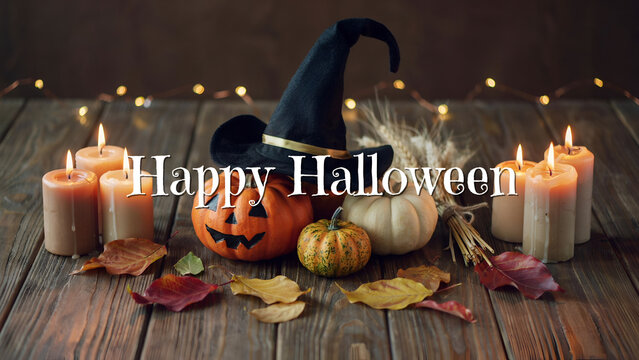 Happy halloween text with jack-o'-lantern, witch hat, and candles on wood