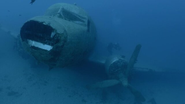 log footage of an airplane wreck underwater scuba divers to explore  metal on ocean floor