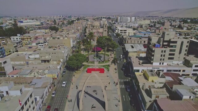 Aerial view of Tacna Cathedral and the surrounding city center with palm trees, urban streets, and buildings in Tacna, Tacna, Peru.