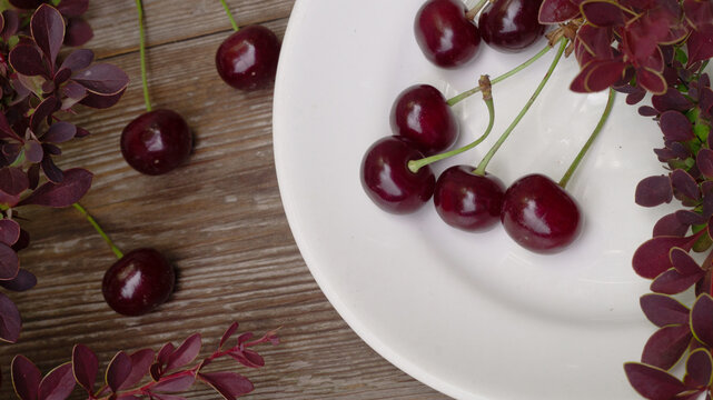 Ripe black cherry on wooden board, macro close-up, cherry wood, garden.