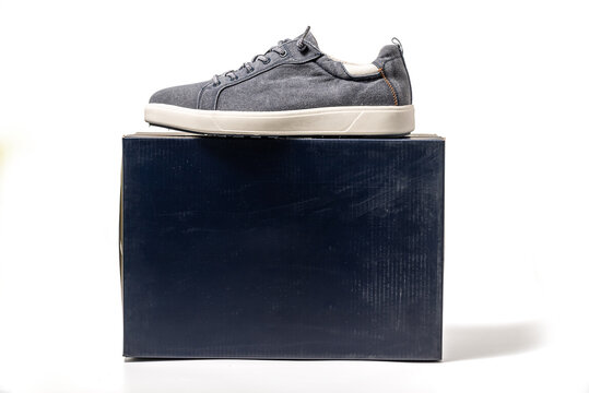 Blue Canvas Sneakers. Sport shoes with a package box isolated on white background, clipping path included