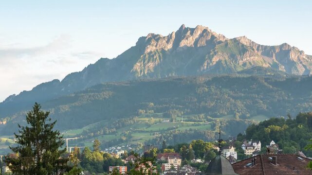 Sunset time lapse of Mount Pilatus with moving shadows over the historic skyline of Lucerne, Switzerland, highlighting alpine peaks