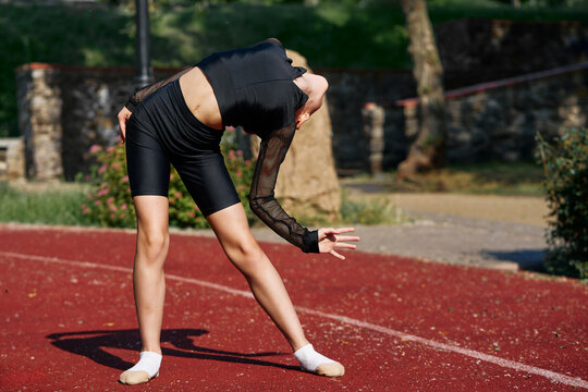 Young Athlete Posing Gracefully During an Outdoor Gymnastics Practice