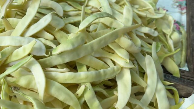 Fresh sliced Romano beans displayed at local farmers market with green flat bean strips prepared for home cooking and seasonal healthy meals