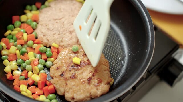 Person cooking a plant-based burger in a modern kitchen. Meat alternative for healthy eating, sustainable food. Protein-rich nutrition, lower carbon footprint, longevity and eco-friendly lifestyle.
