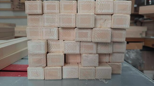 Dynamic Handheld Push In And Pull Out Shot Of Neatly Stacked Processed Wooden Blocks With Rounded Edges Resting On Messy Workbench Inside Rustic Joinery Workshop Authentic Documentary B-Roll
