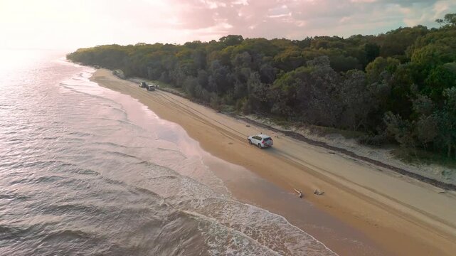Aerial View of 4WD Vehicle Driving on Fraser Island Beach Road Through Coastal Forest at Dusk