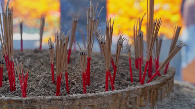 Slow motion of smoke rising from incense pot at Buddhist temple.