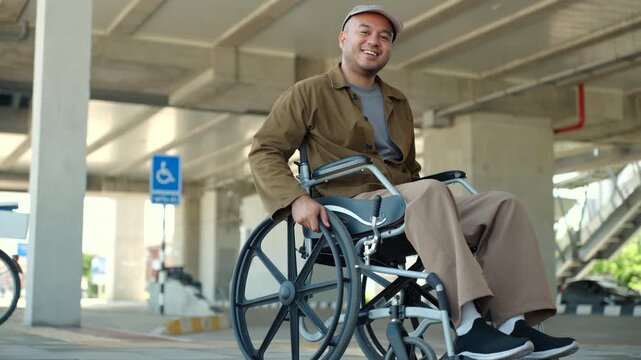 Happy disabled man using a wheelchair independently on accessible city sidewalk with barrier-free infrastructure. Equal access. Smart city, disability rights. Independent mobility.
